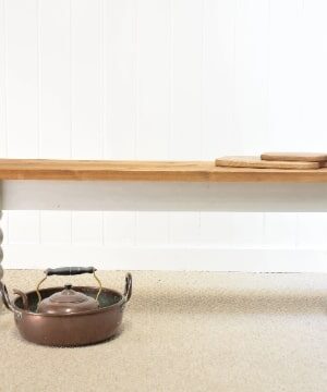 A pot sitting on top of a table next to a bench.